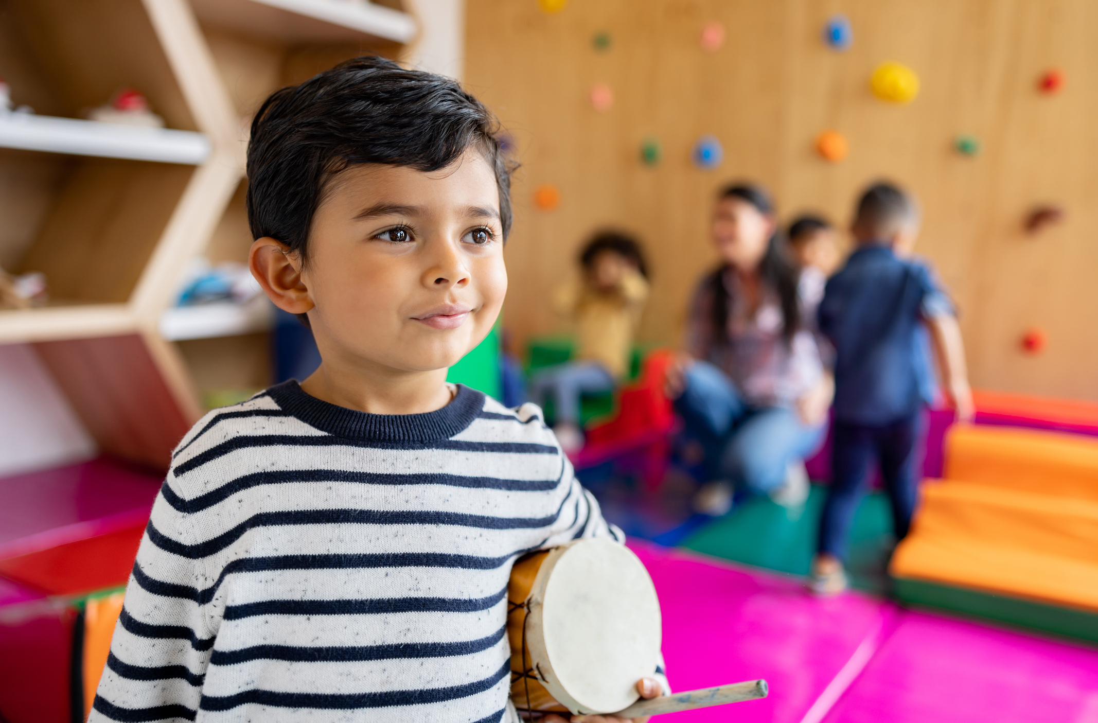 Portrait of a happy Latin American boy in music class at school and smiling - education concepts